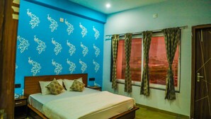 A bedroom with a bed, curtains, a window, and a ceiling fan.