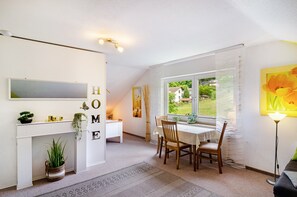 Un interior moderno con comedor, chimenea blanca y vistas al exterior.