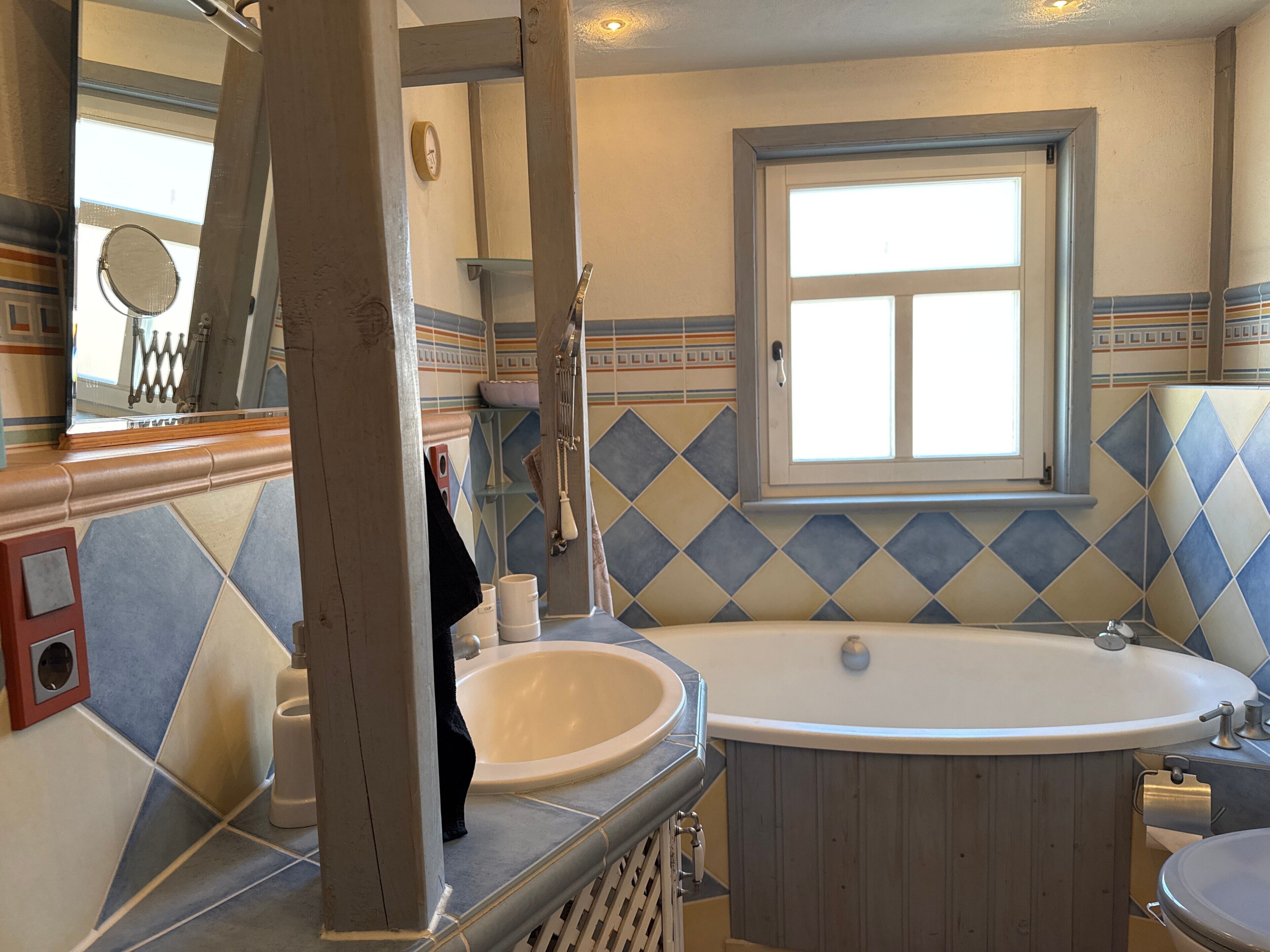 A bathroom with a freestanding bathtub, a sink, and a mirror.