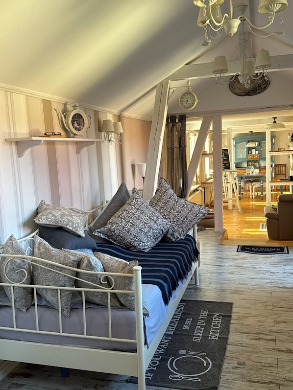 Ein Schlafzimmer mit Bett, Kissen, einer Uhr und einem Kronleuchter.