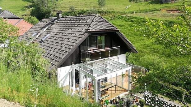 A modern house with a sloped roof, a glass balcony, and a view of a green field. - Apartment 'Glashütte' with Mountain View, Balcony and Wi-Fi (Sankt Märgen)