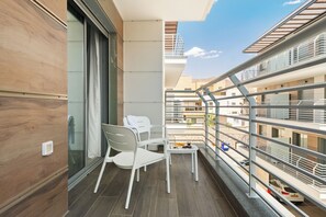 A balcony with a dining table and chairs, a view of the cityscape, and a railing. - Red Canyon Spa Cozy Stay by Sea N' Rent (Eilat)