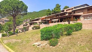 A hillside building with multiple levels, outdoor terraces, and a mix of modern and traditional architecture. - Cosy apartment in Olbia (Olbia)