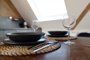 Una mesa con un bol, una copa de vino y un tenedor.