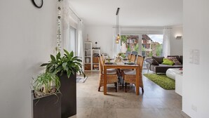 Um espaço de estar moderno com área de refeições, um sofá e vista para o exterior.