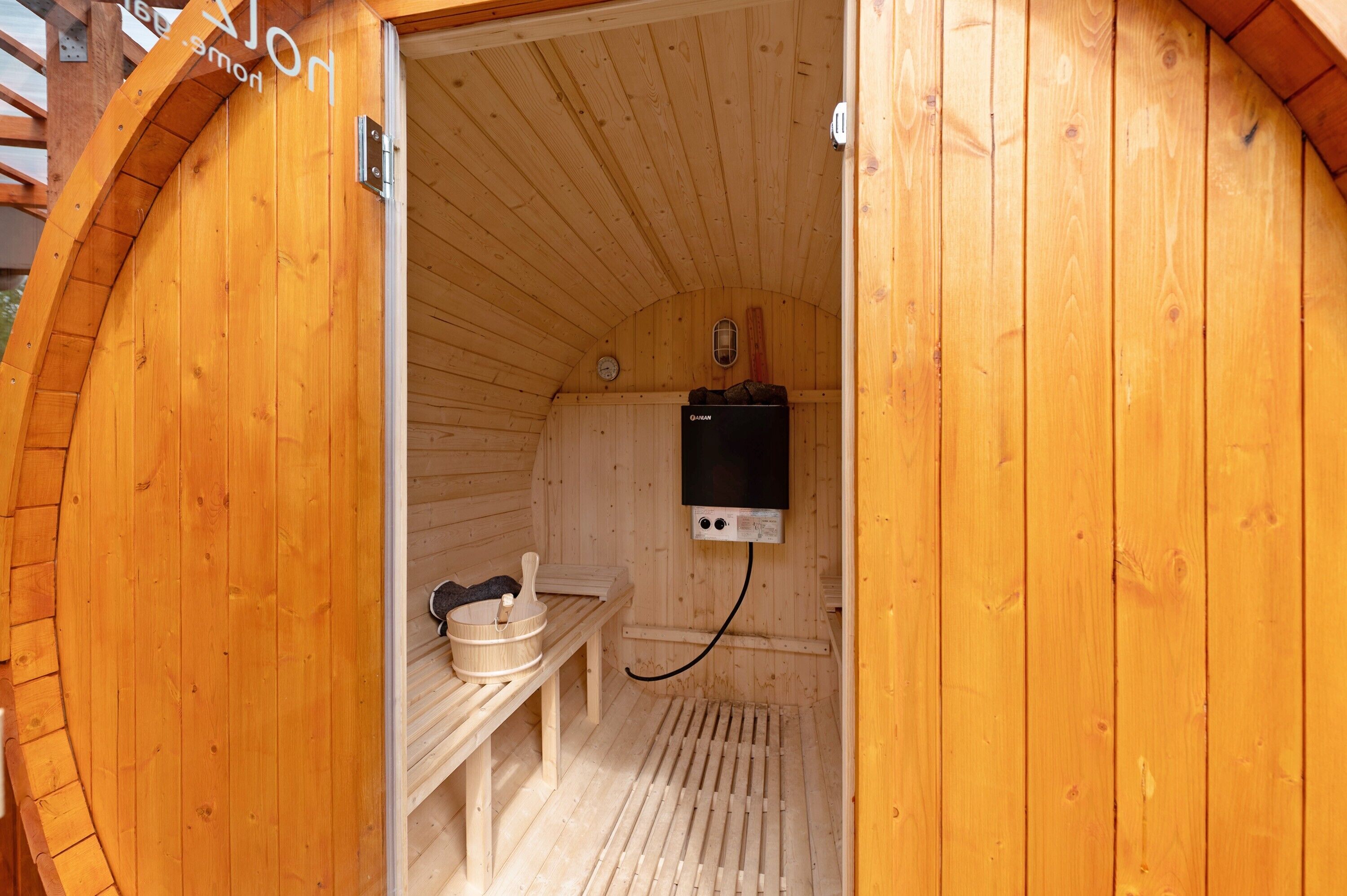 Un sauna en bois, équipé d’un banc et d’un appareil de chauffage.