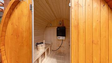 Un sauna en bois, équipé d’un banc et d’un appareil de chauffage.