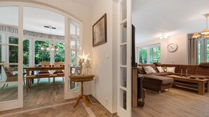 An open-plan living area with a dining table, sofa, and a star-shaped lamp. - Holiday Home 'Im Grünen' with Private Terrace, Private Garden and Wi-Fi (Harsefeld)