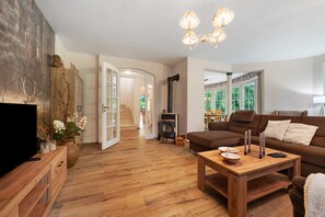 A living room with a wooden coffee table, a brown sofa, a TV, and a fireplace.