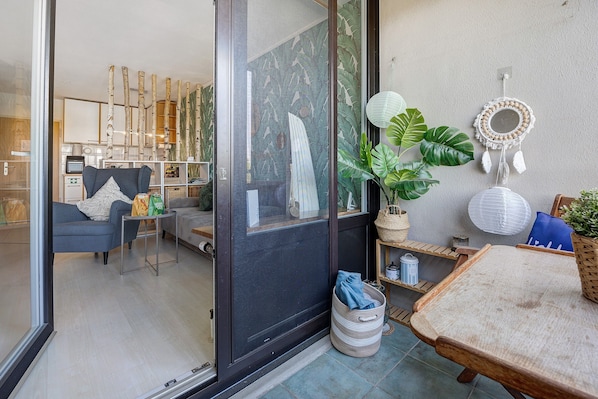 Un salon moderne comprenant un canapé, une table basse, une table à manger et une porte-fenêtre coulissante donnant sur une autre pièce.