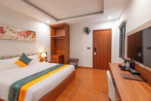 A hotel room with a large bed, wooden wardrobe, bedside table with lamp, and a large mirror. - VIET TRUNG Hotel (Lao Cai)