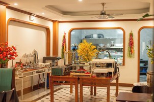 Un comedor con una mesa de madera, sillas y vista a la cocina a través de un ventanal grande.