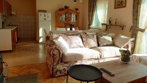 Una sala de estar acogedora con un sofá, una mesa de comedor y una cocina al fondo.