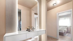 Une salle de bain moderne avec un meuble-lavabo blanc, un grand miroir et un luminaire placé au-dessus du miroir.