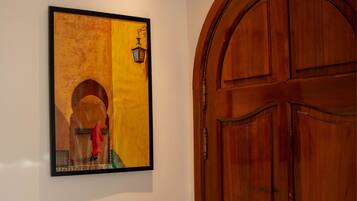 Una obra de arte enmarco en una pared junto a una puerta de madera.