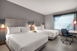 Una habitación de hotel con dos camas, un escritorio y una silla.
