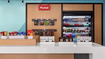 A market area with snack displays and a refrigerated beverage section.