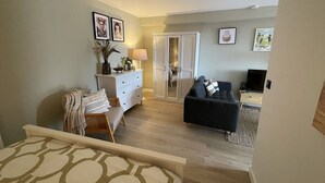 Un salon comprenant un canapé, un téléviseur, un meuble et une armoire.