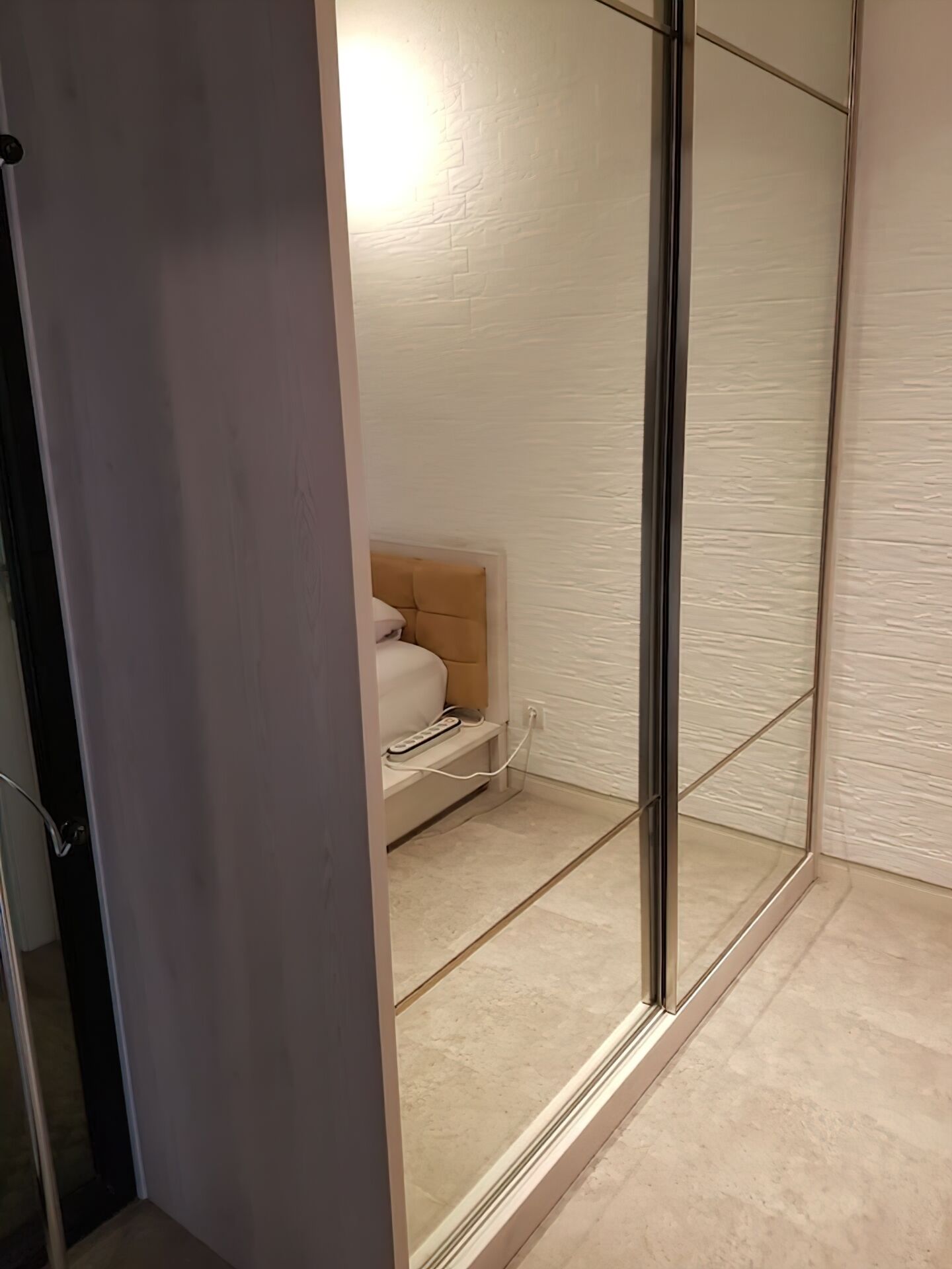 Un baño moderno con cabina de ducha de vidrio, bañera color beige y pared blanca con textura.