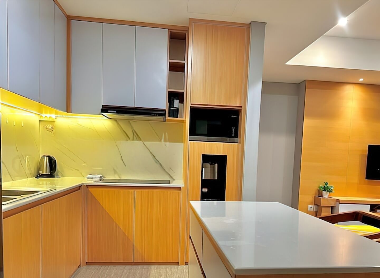 A modern kitchen with wooden cabinets, a stainless steel sink, and a built-in microwave.