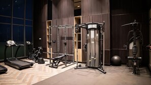 Stay fit on the go with our well-equipped gym featuring treadmills, a bench press, squat rack, and cable machine.