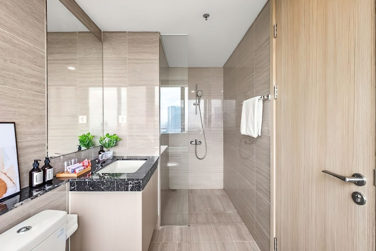 Une salle de bain moderne avec un lavabo en marbre, une douche à parois de verre et une porte en bois.