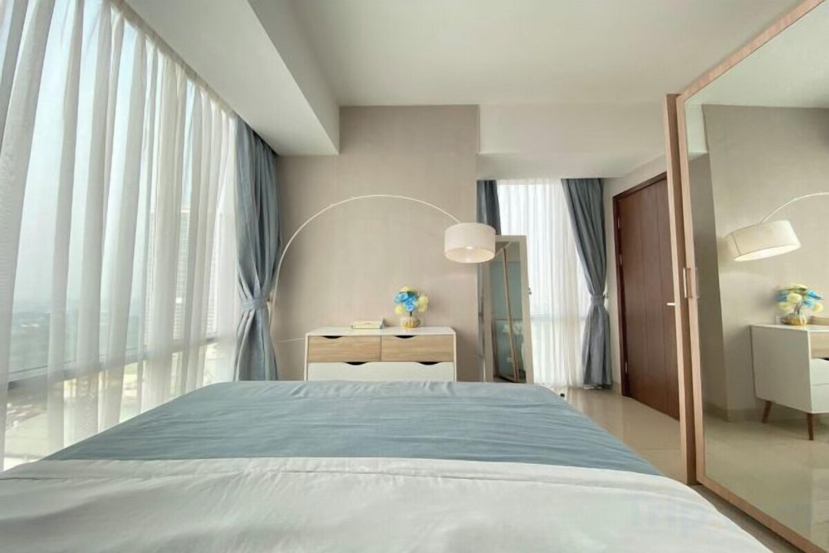 Ein modernes Hotelzimmer mit einem großen Bett, einem Schreibtisch und einem Spiegel.