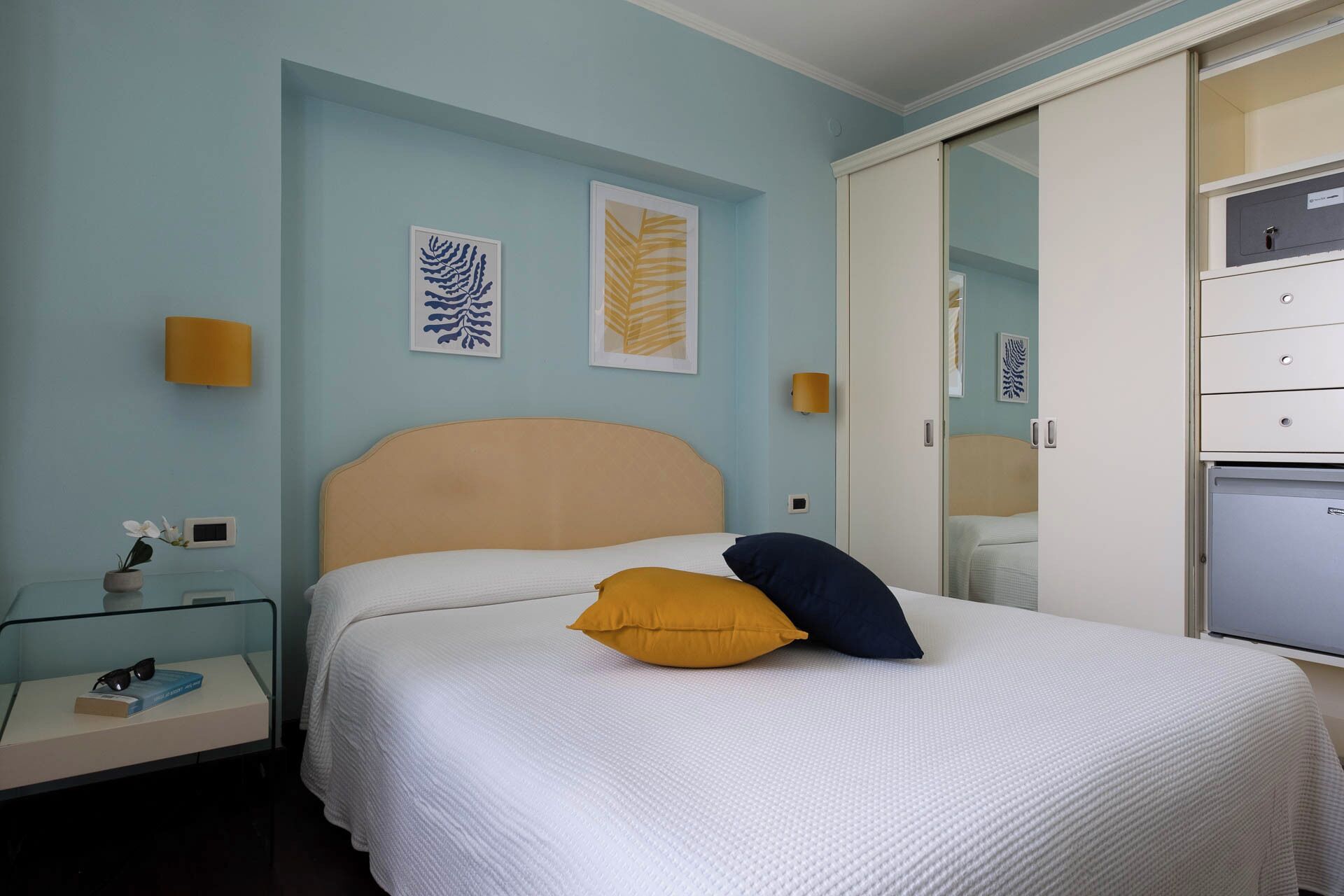 Une chambre à coucher avec un lit, des tables de chevet et une armoire.