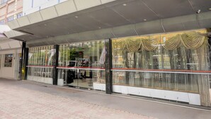 Un edificio moderno con grandes ventanales y un acceso cubierto.