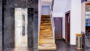Una escalera de mármol con un diseño único tipo raya de tigre, que conduce a una puerta.