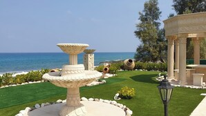 Ein Garten mit Brunnen, Laube und Meerblick.