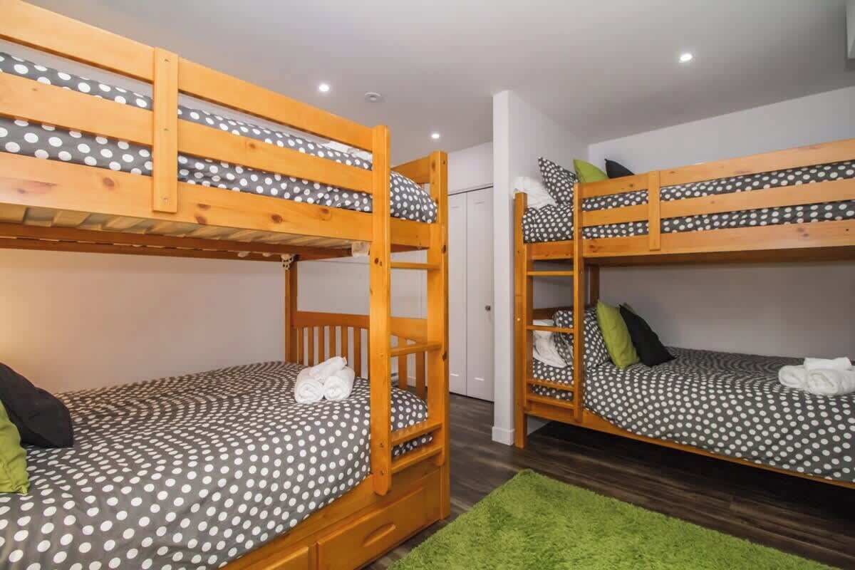 Een kamer met twee stapelbedden, elk met een bloemrijk beddegoed en kussens.