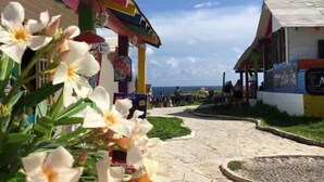 A pathway leading to a building with a colorful facade and a sign that reads "HOTEL". - Luxury One Minute Beach Pool Soak Fast WIFI Villa (Isla Mujeres)
