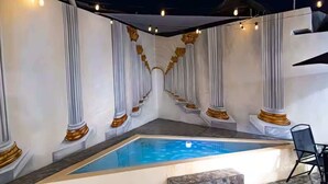 A swimming pool with white columns and gold accents, surrounded by stone steps and a chair. - Luxury One Minute Beach Pool Soak Fast WIFI Villa (Isla Mujeres)