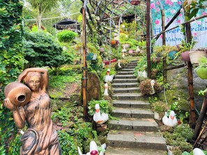 A garden with a stone staircase surrounded by lush greenery and decorative swans. - Sea Breeze Resort & Spa (Phu Quoc)