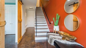 A staircase with a wooden handrail and a white door at the top.