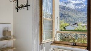 Un dormitorio con un ventanal grande que da a un paisaje montañoso.