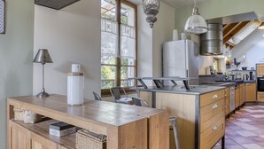 Una cocina moderna con armarios de madera, una isla central e iluminación colgante.