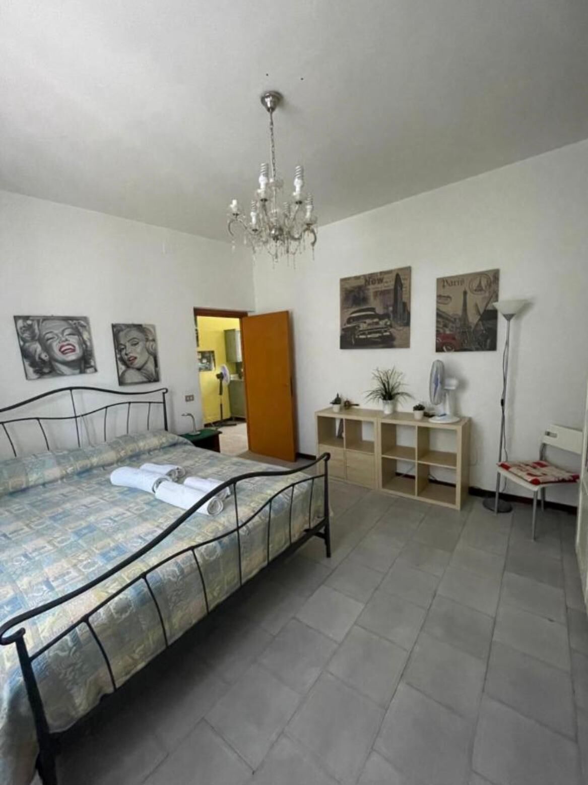 Ein Schlafzimmer mit Bett, einer Deckenleuchte, einem Schreibtisch und einem Stuhl.