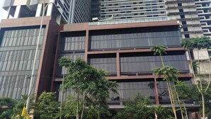 Un moderno edificio de rascacielos con múltiples pisos, grandes ventanales y fachadas de vidrio y concreto.