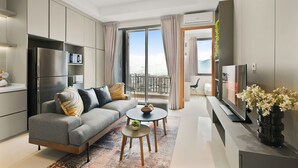 A modern living room with a sofa, coffee table, and TV. - Samara Suites by Emily in Jakarta (Jakarta)