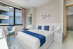 Relax in a stylish room with a large bed, desk, and city view.