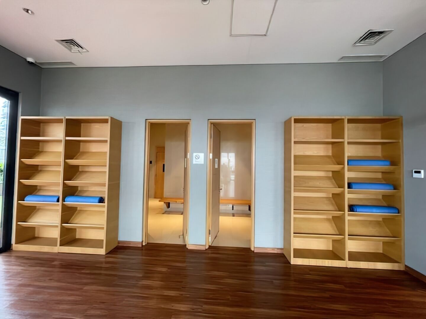 A spacious room with wooden shelving units and a door leading to another room.