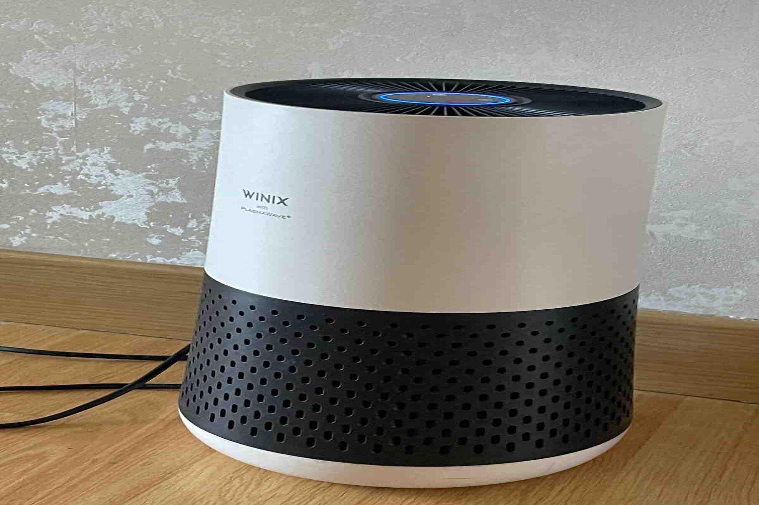Un haut-parleur intelligent WIX doté d’une base perforée et d’un dessus circulaire avec une lumière bleue.