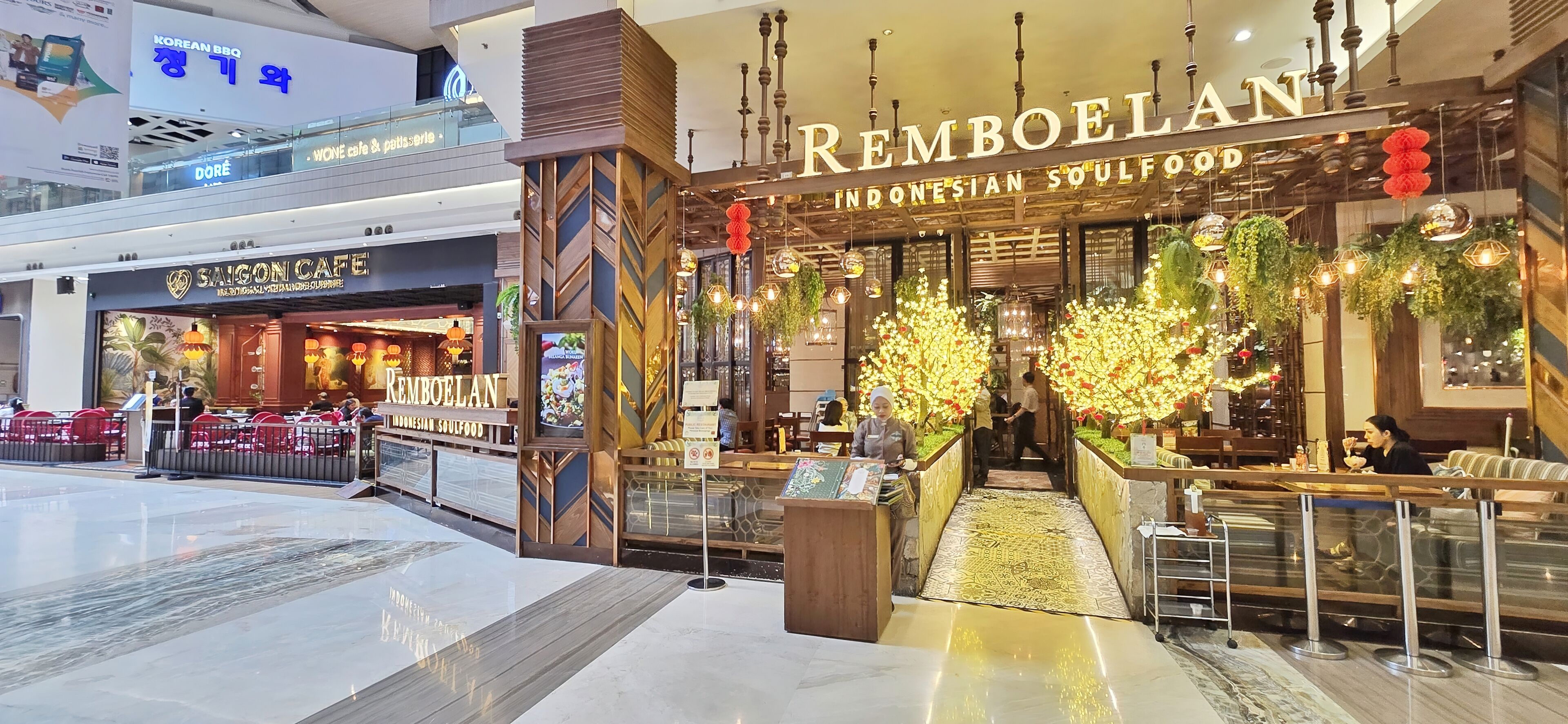 Un restaurant appelé « REMBOELAN », doté d’un intérieur moderne et offrant une vue sur le centre commercial.