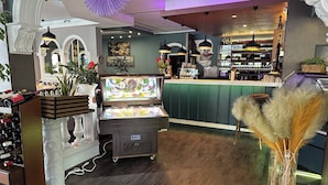 A bar area with a counter, ice cream display, and various bottles. - HOTEL BONÉ TO (Salzgitter)