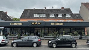 A building with signs for a steakhouse, bistro, and restaurant. - HOTEL BONÉ TO (Salzgitter)