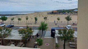 Vista a la playa con un área de estacionamiento y un restaurante con terraza.