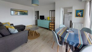 Una sala de estar moderna con sofá, mesa de comedor y televisor.