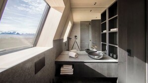 Une salle de bain moderne avec une grande fenêtre, un lavabo et un miroir.